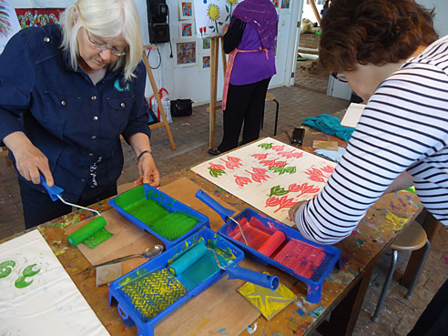 Het linoleum wordt met textielinkt ingerold zodat het afgedrukt kan worden op het kussensloop